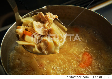 從鍋子裡舀出的豬肉湯食材 137301362