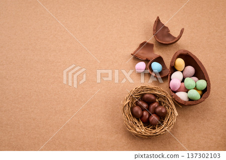 Chocolate easter eggs and candy scattered on brown background Chocolate easter eggs and candy scattered on brown background 137302103