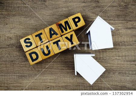 Stamp Duty alphabet letters with house model on wooden background Stamp Duty alphabet letters with house model on wooden background 137302954