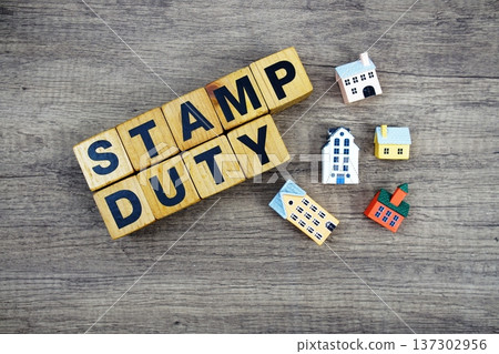 Stamp Duty alphabet letters with house model on wooden background Stamp Duty alphabet letters with house model on wooden background 137302956