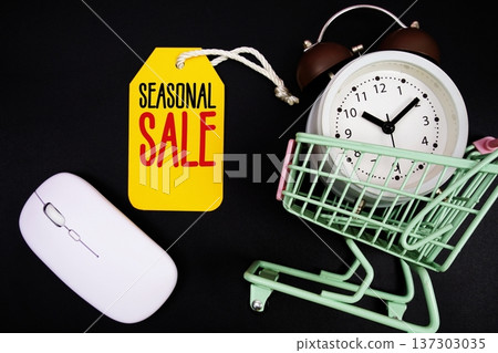 Seasonal Sale text with price tag, optical mouse, trolly cart and alarm clock on black background, Shopping Online Concept Seasonal Sale text with price tag, optical mouse, trolly cart and alarm clock on black background, Shopping Online Concept 137303035