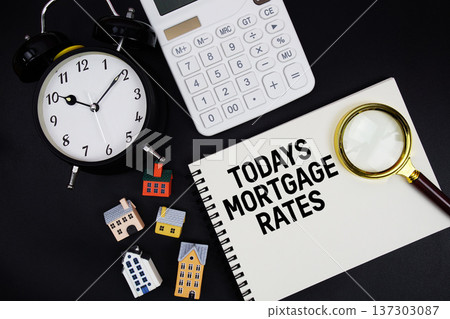 Notepad with the phrase "Todays Mortgage Rates" surrounded by a pen, calculator, magnifying glass, clock, and house model Notepad with the phrase "Todays Mortgage Rates" surrounded by a pen, calculator, magnifying glass, clock, and house model 137303087