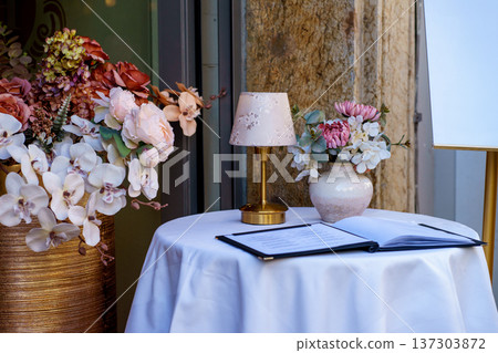 Decorated cafe table with floral arrangement and menu. Fine dining concept, wedding reception setup and elegant hospitality theme. 137303872