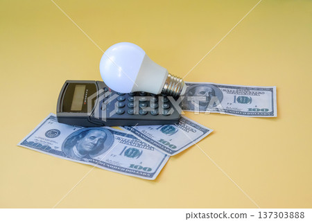 A calculator with light bulb and banknote on background, Energy saving concept. 137303888