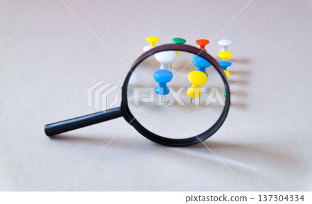 Magnifying glass on push pin over background. Magnifying glass on push pin over background. 137304334