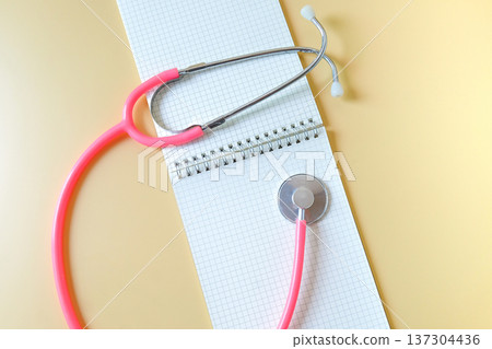 Pink Stethoscope on booknote, Medical accessories on background. Pink Stethoscope on booknote, Medical accessories on background. 137304436