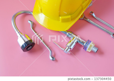 A composition with plumber's tools , Faucet and yellow helmet. A composition with plumber's tools , Faucet and yellow helmet. 137304450