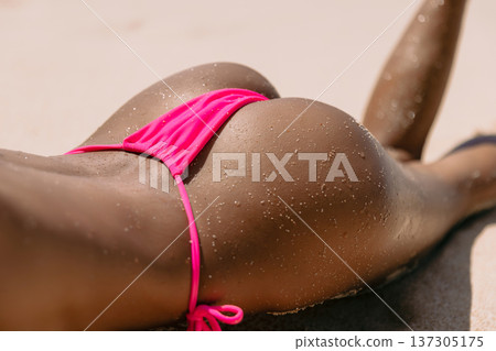Close up of woman body in bikini sunbathing on sandy beach 137305175