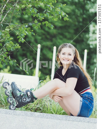 Young woman riding roller skates 137305351