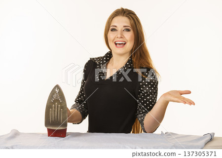 Happy woman doing ironing Happy woman doing ironing 137305371