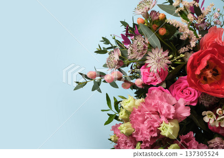 Floral bouquet with pink roses, astrantia, and carnations on blue background. Copy space for greetings, invitations, or spring promotions. 137305524