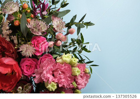 Floral bouquet with pink roses, astrantia, and greenery on a light blue background. Copy space for wedding, birthday, or spring designs. 137305526