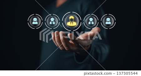 person holds glowing digital icons of people with one highlighted in yellow symbolizing customer focus,relationship management,loyalty,personalization,network building,and modern business connections. 137305544