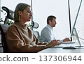 Two people are working on a computer, one of them is typing on a keyboard 137306944