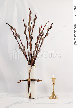Burning candle and young flowering pussy willow branches in a vase on a kitchen table. Palm Sunday concept, preparation for Easter celebrations, design template with space for text 137307605