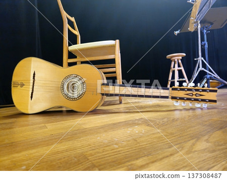 A handcrafted chitarra battente, a traditional Italian instrument, rests on the stage floor. 137308487