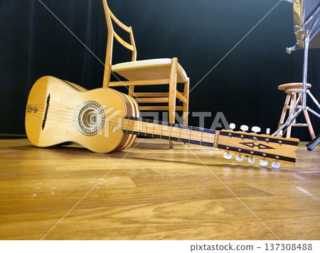 A handcrafted chitarra battente, a traditional Italian instrument, rests on the stage floor. 137308488