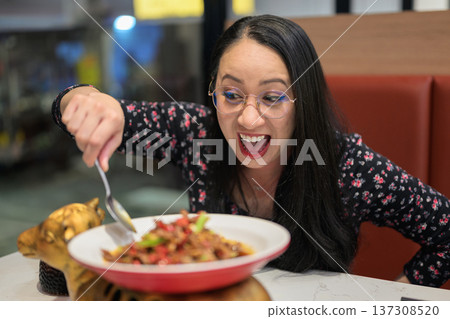 Excited Happy Woman Tasting Spicy Chinese Asian Food in Modern Restaurant Excited Happy Woman Tasting Spicy Chinese Asian Food in Modern Restaurant 137308520