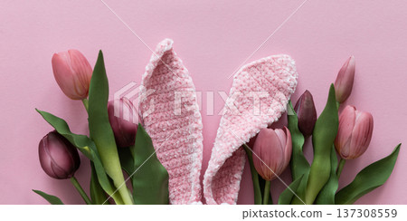 Easter Knitted Bunny Ears with Pink Tulips on Pink Background. Spring Holiday Flat Lay Easter Knitted Bunny Ears with Pink Tulips on Pink Background. Spring Holiday Flat Lay 137308559