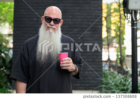 Bald Man with Long White Beard Holding Coffee Outdoors Bald Man with Long White Beard Holding Coffee Outdoors 137308608