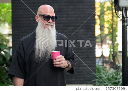 Bald Man with Long White Beard Holding Coffee Outdoors Bald Man with Long White Beard Holding Coffee Outdoors 137308609