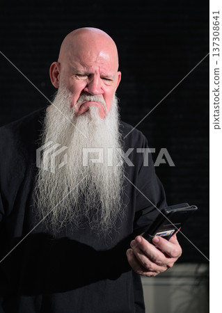 Bald Bearded Man Showing Sad Reaction to Smartphone Message 137308641