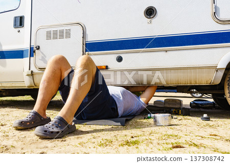 Man repairing bottom of the rv caravan Man repairing bottom of the rv caravan 137308742