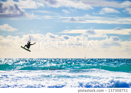Kite surfer riding waves. Kiteboarding sport. 137308751