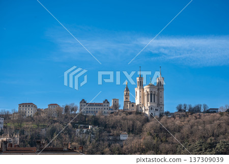Lyon, france. December 27, 2023. Notre dame de fourviere basilica atop fourviere hill overlooking lyon skyline under a clear blue winter sky, historic landmark Lyon, france. December 27, 2023. Notre dame de fourviere basilica atop fourviere hill overlooking lyon skyline under a clear blue winter sky, historic landmark 137309039