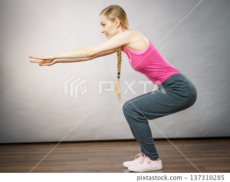 Woman training at home doing sit ups squats Woman training at home doing sit ups squats 137310285