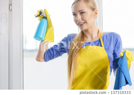 Woman cleaning window at home Woman cleaning window at home 137310333