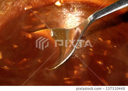 Close up of sweet and sour red sauce being cooked Close up of sweet and sour red sauce being cooked 137310448