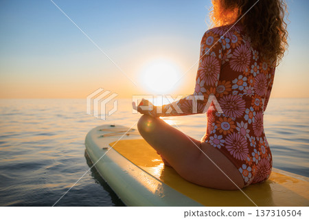 Young woman walking on sup board by the sea during summer vacation Young woman walking on sup board by the sea during summer vacation 137310504