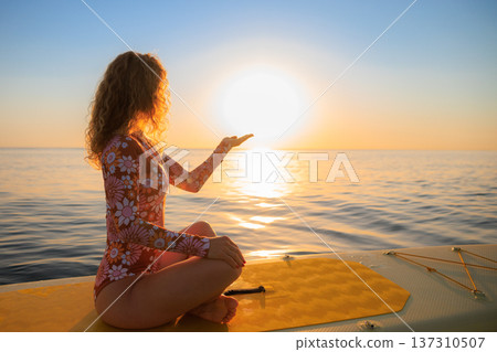 Young woman walking on sup board by the sea during summer vacation 137310507