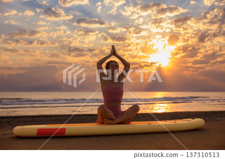Athlete woman practicing yoga at the beach during summer vacation. Slow motion Athlete woman practicing yoga at the beach during summer vacation. Slow motion 137310513