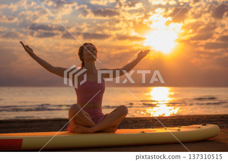 Athlete woman practicing yoga at the beach during summer vacation. Slow motion Athlete woman practicing yoga at the beach during summer vacation. Slow motion 137310515
