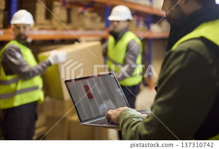Closeup laptop tracking inventory as warehouse workers handle boxes on racks Closeup laptop tracking inventory as warehouse workers handle boxes on racks 137310742