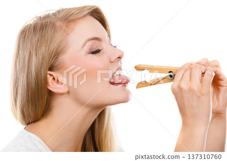 Blonde woman having tongue in clothespin Blonde woman having tongue in clothespin 137310760