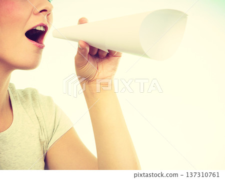 Woman screaming through megaphone made of paper Woman screaming through megaphone made of paper 137310761
