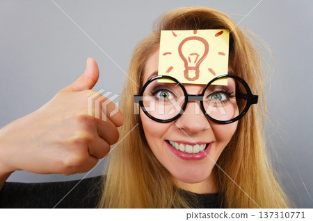 Woman having light bulb mark on forehead thinking 137310771