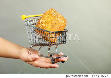 Woman hand holding shopping cart with bread 137310774