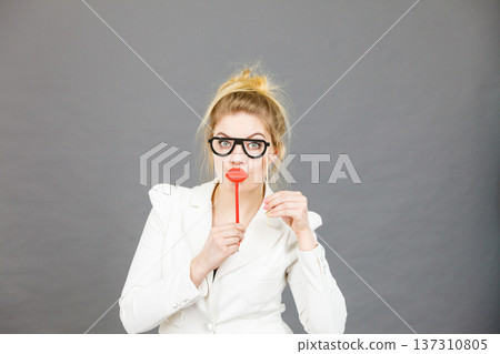 Happy elegant woman holding carnival accessoies on stick Happy elegant woman holding carnival accessoies on stick 137310805