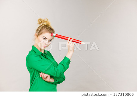 Woman confused thinking, big pencil in hand Woman confused thinking, big pencil in hand 137310806