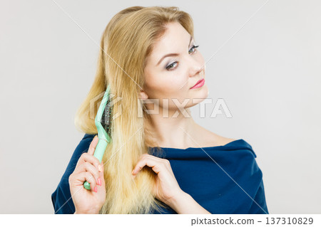 Woman brushing her long hair with brush Woman brushing her long hair with brush 137310829