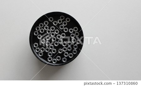 Plastic Tray With Scattered Hex Nuts On Clean White Plastic Sheet Plastic Tray With Scattered Hex Nuts On Clean White Plastic Sheet 137310860