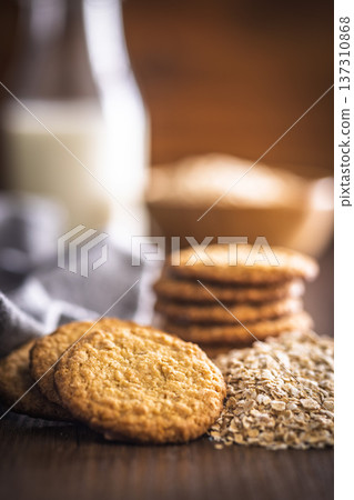 Cookies made with oats and oats scattered on wooden surface during daytime in a kitchen setting Cookies made with oats and oats scattered on wooden surface during daytime in a kitchen setting 137310868