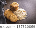 Cookies made with oats and oats scattered on wooden surface during daytime in a kitchen setting 137310869