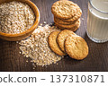 Cookies made with oats and oats scattered on wooden surface during daytime in a kitchen setting 137310871