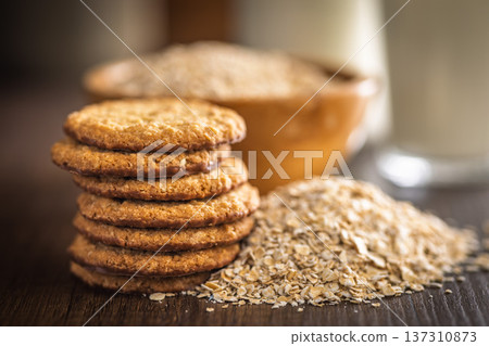 Cookies made with oats and oats scattered on wooden surface during daytime in a kitchen setting Cookies made with oats and oats scattered on wooden surface during daytime in a kitchen setting 137310873