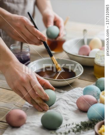 Painting Easter eggs with brush and pastel dyes 137310965